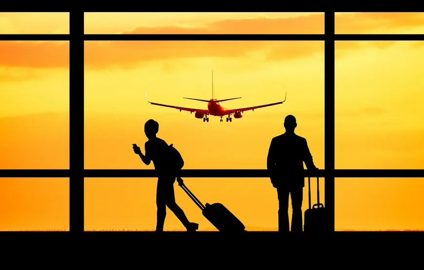 due-figure-in-silohuettes-sono-davanti-alla-vetrata-di-un-aeroporto-guardano-un-aereo-decollare